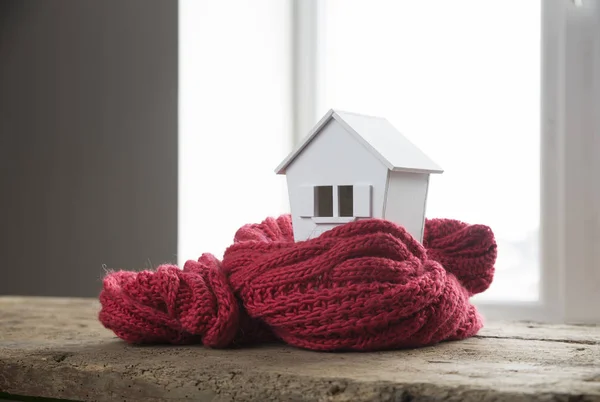 Будинок взимку концепція системи опалення і холодна сніжна погода з моделлю будинку в трикотажній шапці — стокове фото