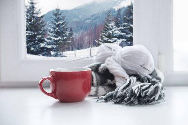 Kış City Kupası içinde belgili tanımlık geçmiş pencere üzerinde sıcak bir içecek ile. Kupası kenarında odaklanmak