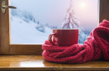 Bir fincan kahve veya çay, akıllı telefon ve kulaklık ile bir pencere yakınında sonbahar yaprakları. Sonbahar playlist kavramı. Yağmurlu günler için sonbahar müzik.