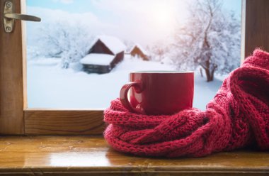 Bir fincan kahve veya çay, akıllı telefon ve kulaklık ile bir pencere yakınında sonbahar yaprakları. Sonbahar playlist kavramı. Yağmurlu günler için sonbahar müzik.