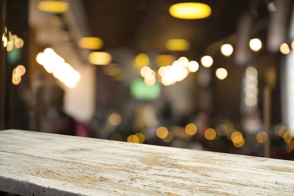 Obraz dřevěného stolu před abstraktním rozmazaným pozadím obnovujících světel — Stock fotografie