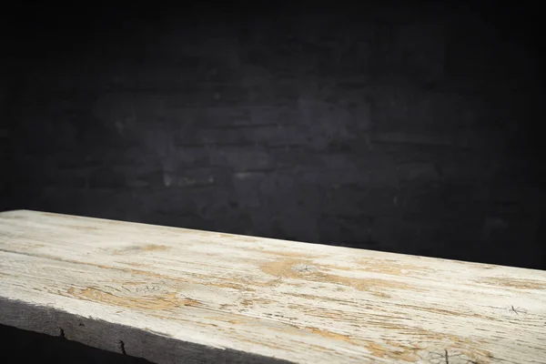 Old wood table with flame effect on dark background.