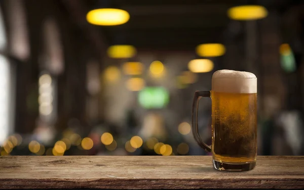 Lunettes avec bière froide sur la table sur fond flou — Photo