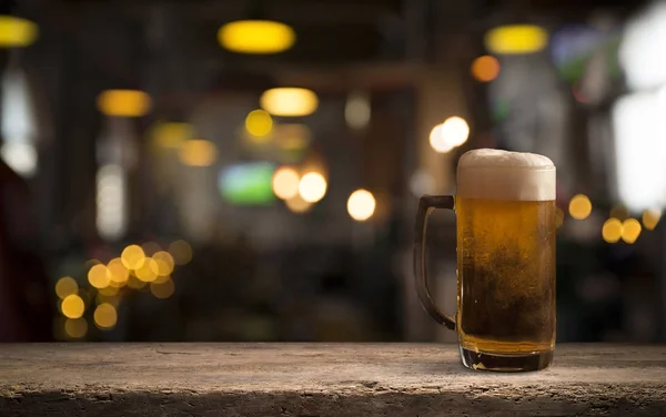 Lunettes avec bière froide sur la table sur fond flou — Photo