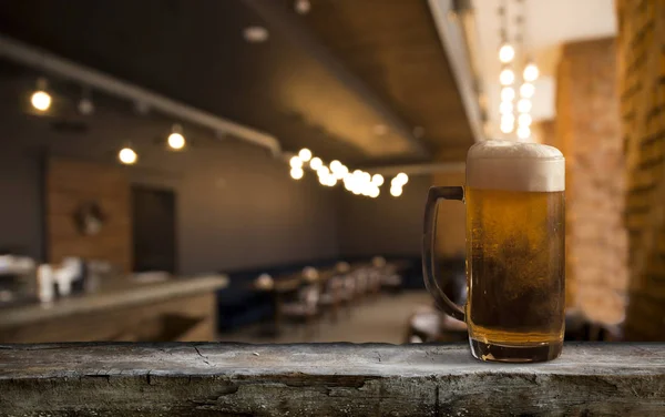 Gläser mit kaltem Bier auf dem Tisch vor verschwommenem Hintergrund — Stockfoto