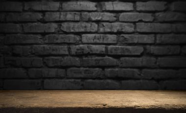 Seçili odak boş kahverengi ahşap masa ve duvar dokusu veya eski siyah tuğla duvar arkaplan bulanık görüntüsü. Fotomontaj ya da ürün gösterimi için