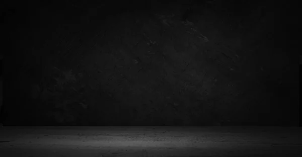 cement floor in dark room with spot light. black background.