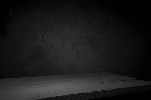 cement floor in dark room with spot light. black background.