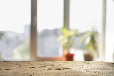 Pencere camından bulanık ahşap masa üstü ve bahçe manzaralı soyut yeşil sabah arka planda. Montaj ürünü görüntüsü için