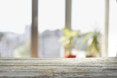 Pencere camından bulanık ahşap masa üstü ve bahçe manzaralı soyut yeşil sabah arka planda. Montaj ürünü görüntüsü için