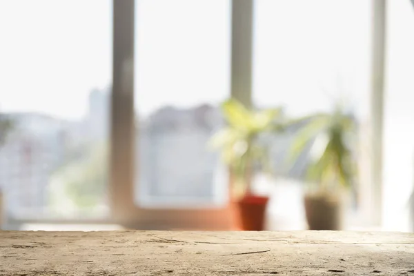 Hout tafelblad op waas van vensterglas en abstract groen uit de tuin met uitzicht op de stad in de ochtend achtergrond. Voor montage product display — Stockfoto