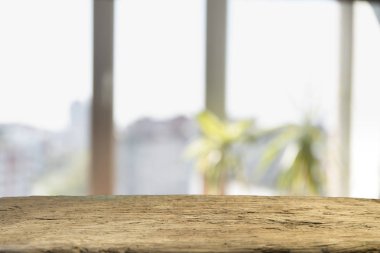 Pencere camından bulanık ahşap masa üstü ve bahçe manzaralı soyut yeşil sabah arka planda. Montaj ürünü görüntüsü için