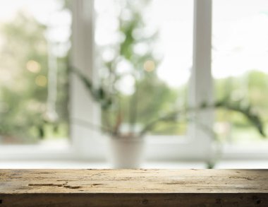 Pencere camından bulanık ahşap masa üstü ve bahçe manzaralı soyut yeşil sabah arka planda. Montaj ürünü görüntüsü için