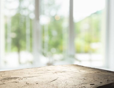 Pencere camından bulanık ahşap masa üstü ve bahçe manzaralı soyut yeşil sabah arka planda. Montaj ürünü görüntüsü için