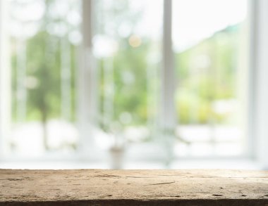 Pencere camından bulanık ahşap masa üstü ve bahçe manzaralı soyut yeşil sabah arka planda. Montaj ürünü görüntüsü için
