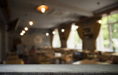 Kafenin soyut bulanık arka planının önündeki boş ahşap masa. Ürünlerinizi görüntülemek veya montajlamak için kullanılabilir. Ürünün görüntülenmesi için modelleyin