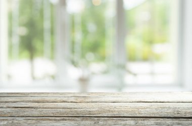 Pencere camından bulanık ahşap masa üstü ve bahçe manzaralı soyut yeşil sabah arka planda. Montaj ürünü görüntüsü için