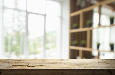 Pencere camından bulanık ahşap masa üstü ve bahçe manzaralı soyut yeşil sabah arka planda. Montaj ürünü görüntüsü için