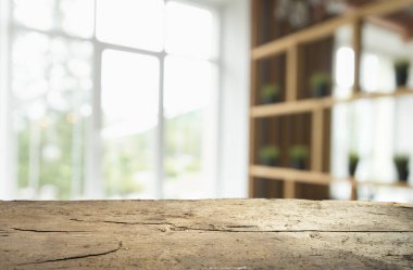 Pencere camından bulanık ahşap masa üstü ve bahçe manzaralı soyut yeşil sabah arka planda. Montaj ürünü görüntüsü için