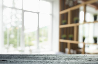 Pencere camından bulanık ahşap masa üstü ve bahçe manzaralı soyut yeşil sabah arka planda. Montaj ürünü görüntüsü için