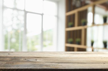 Pencere camından bulanık ahşap masa üstü ve bahçe manzaralı soyut yeşil sabah arka planda. Montaj ürünü görüntüsü için