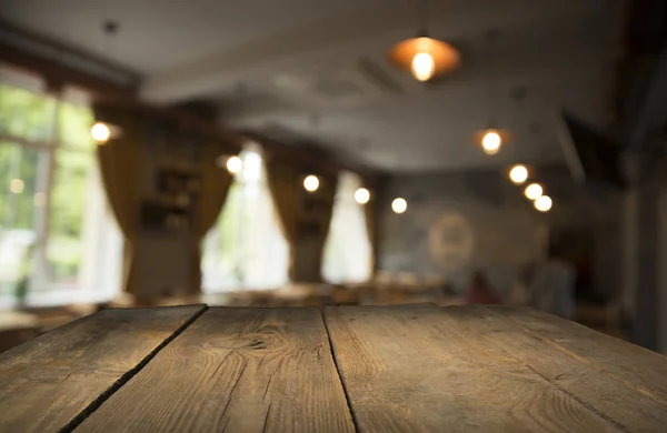 Empty wooden table in front of abstract blurred background of coffee shop . can be used for display or montage your products.Mock up for display of product