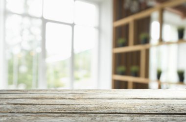 Pencere camından bulanık ahşap masa üstü ve bahçe manzaralı soyut yeşil sabah arka planda. Montaj ürünü görüntüsü için