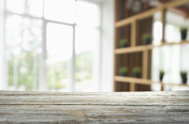 Pencere camından bulanık ahşap masa üstü ve bahçe manzaralı soyut yeşil sabah arka planda. Montaj ürünü görüntüsü için