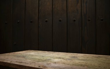 Seçili odak boş kahverengi ahşap masa ve duvar dokusu veya eski siyah tuğla duvar arkaplan bulanık görüntüsü. Fotomontaj ya da ürün gösterimi için