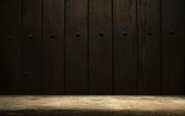 Seçili odak boş kahverengi ahşap masa ve duvar dokusu veya eski siyah tuğla duvar arkaplan bulanık görüntüsü. Fotomontaj ya da ürün gösterimi için