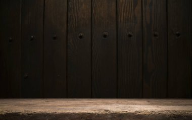 Seçili odak boş kahverengi ahşap masa ve duvar dokusu veya eski siyah tuğla duvar arkaplan bulanık görüntüsü. Fotomontaj ya da ürün gösterimi için
