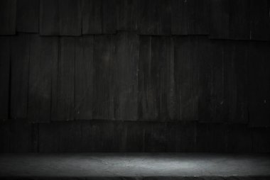 Karanlık oda arka planında bulanık beton duvar olan eski ahşap masa..