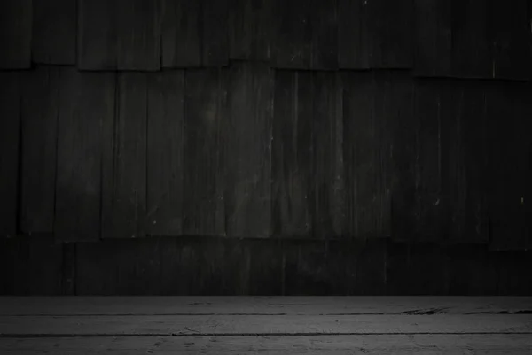 Old wood table with blurred concrete block wall in dark room background. — Stock Photo, Image