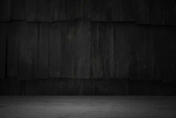 Old wood table with blurred concrete block wall in dark room background. — Stock Photo, Image