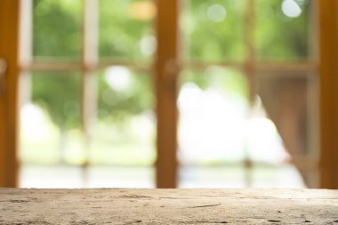 Ağaç bahçe arka planda pencere görünümü yeşil ile perde bulanıklık üzerinde ahşap masa üst boş. Montaj ürün gösterimi veya tasarım anahtarı görsel düzeni için