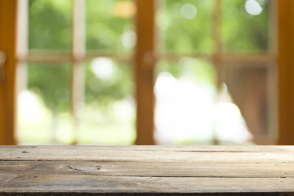 Vazio de tampo de mesa de madeira na desfoque de cortina com janela vista verde de árvore jardim background.For montagem exposição do produto ou design layout visual chave — Fotografia de Stock
