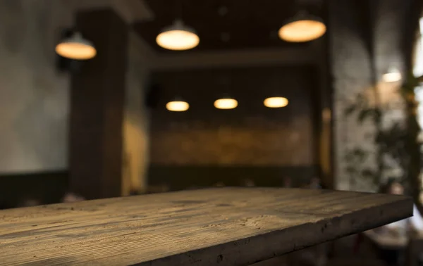 Meja kayu atas dengan merefleksikan kabur cahaya di kafe malam — Stok Foto