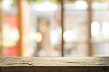 Ağaç bahçe arka planda pencere görünümü yeşil ile perde bulanıklık üzerinde ahşap masa üst boş. Montaj ürün gösterimi veya tasarım anahtarı görsel düzeni için