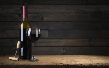 Kırmızı şarap kadehleri ve taş arka planda bir şişe. Kopyalama alanı olan üst görünüm