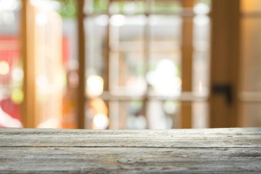 Ağaç bahçe arka planda pencere görünümü yeşil ile perde bulanıklık üzerinde ahşap masa üst boş. Montaj ürün gösterimi veya tasarım anahtarı görsel düzeni için