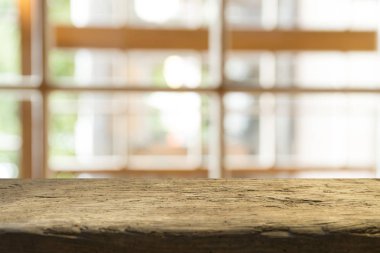 Ağaç bahçe arka planda pencere görünümü yeşil ile perde bulanıklık üzerinde ahşap masa üst boş. Montaj ürün gösterimi veya tasarım anahtarı görsel düzeni için