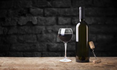 Kırmızı şarap kadehleri ve taş arka planda bir şişe. Kopyalama alanı olan üst görünüm