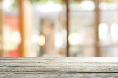 Ağaç bahçe arka planda pencere görünümü yeşil ile perde bulanıklık üzerinde ahşap masa üst boş. Montaj ürün gösterimi veya tasarım anahtarı görsel düzeni için
