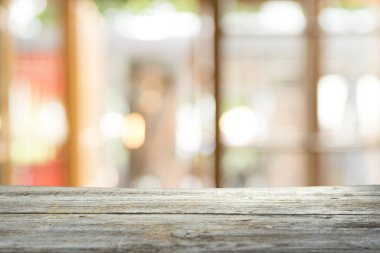 Ağaç bahçe arka planda pencere görünümü yeşil ile perde bulanıklık üzerinde ahşap masa üst boş. Montaj ürün gösterimi veya tasarım anahtarı görsel düzeni için