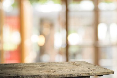 Ağaç bahçe arka planda pencere görünümü yeşil ile perde bulanıklık üzerinde ahşap masa üst boş. Montaj ürün gösterimi veya tasarım anahtarı görsel düzeni için