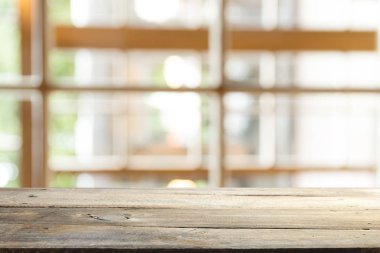 Ağaç bahçe arka planda pencere görünümü yeşil ile perde bulanıklık üzerinde ahşap masa üst boş. Montaj ürün gösterimi veya tasarım anahtarı görsel düzeni için