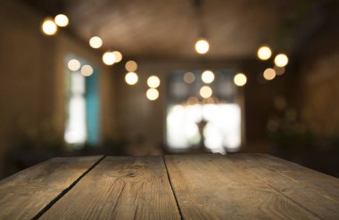 Karanlık arka planda kafe restoranın bulanıklık ışık altın bokeh boş ahşap masa üstü