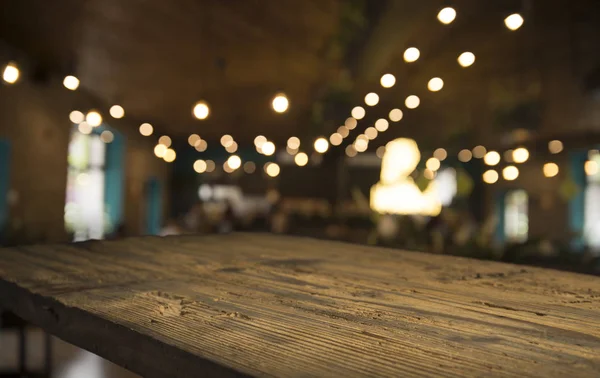 Karanlık arka planda kafe restoranın bulanıklık ışık altın bokeh boş ahşap masa üstü