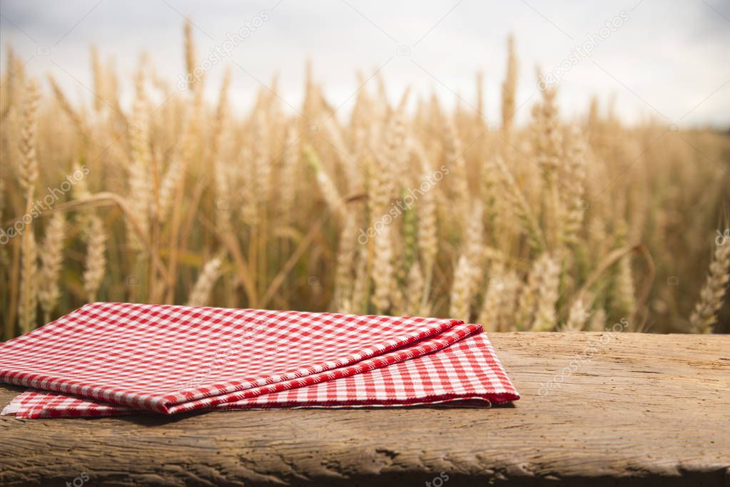 wood board table in front of field of wheat on sunset light. Ready for product display montage