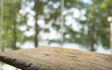 Ağaç bahçe arka planda pencere görünümü yeşil ile perde bulanıklık üzerinde ahşap masa üst boş. Montaj ürün gösterimi veya tasarım anahtarı görsel düzeni için